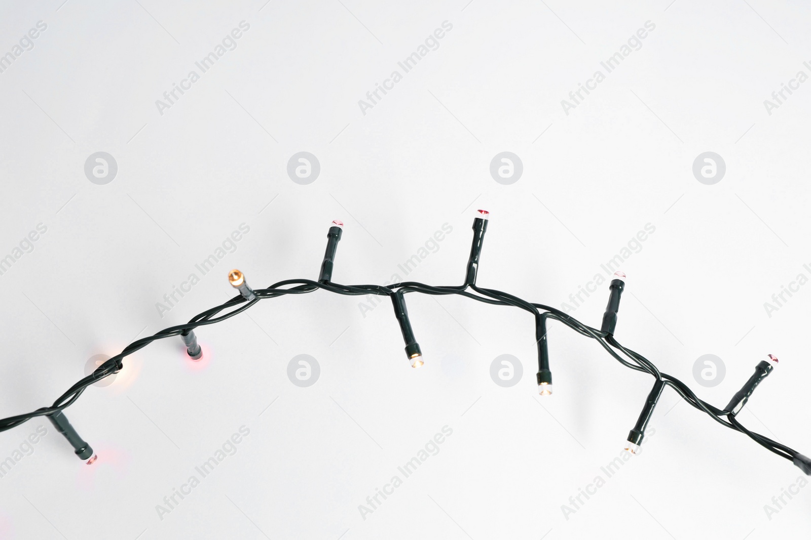 Photo of Beautiful Christmas lights on white background, top view