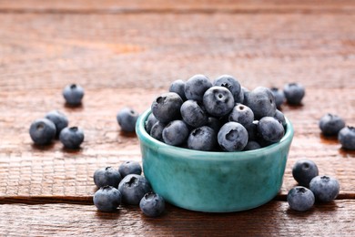 Photo of Tasty fresh blueberries on wooden table, closeup