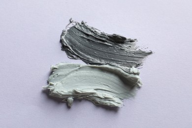 Samples of face mask on lilac background, flat lay