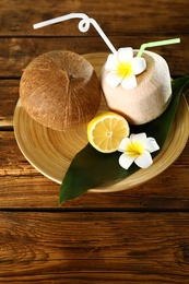 Photo of Plate with coconuts and lemon on wooden table