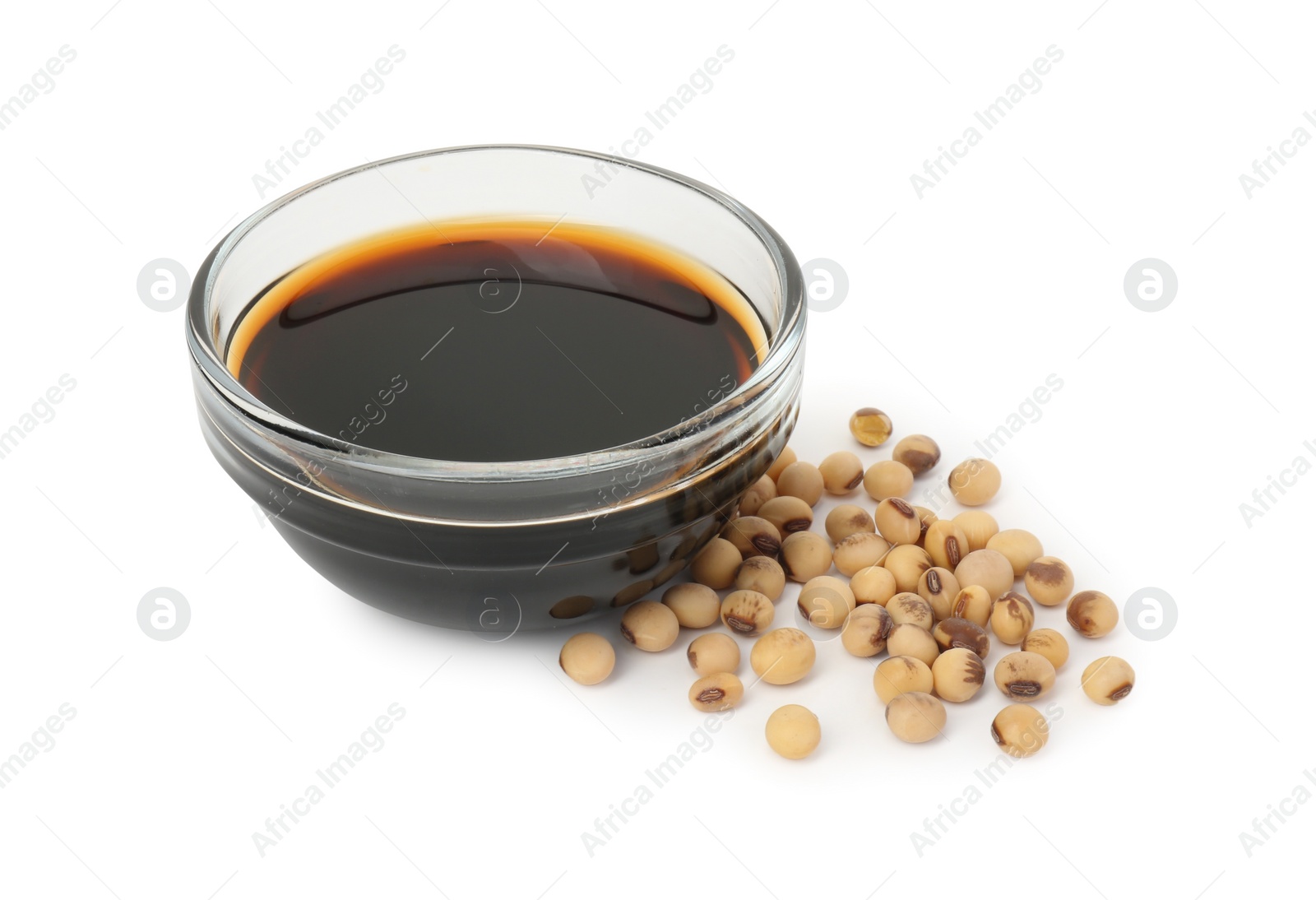 Photo of Tasty soy sauce in bowl and soybeans isolated on white