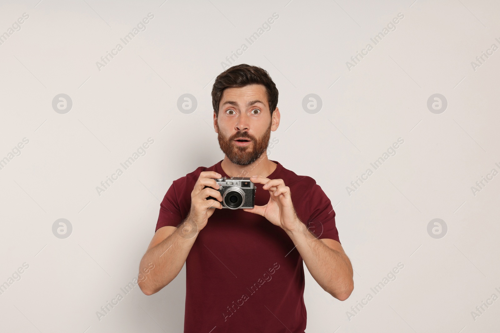 Photo of Man with camera on white background. Interesting hobby