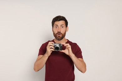 Photo of Man with camera on white background. Interesting hobby