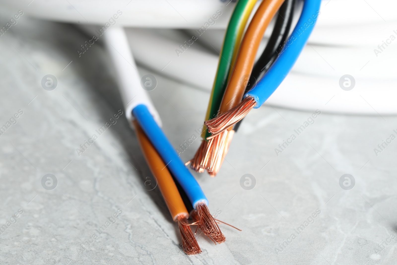 Photo of Colorful electrical wires on gray textured surface, closeup