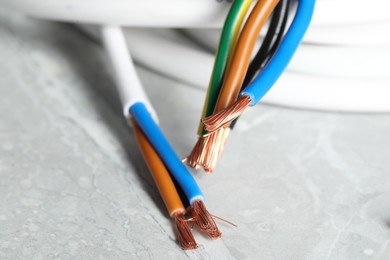 Photo of Colorful electrical wires on gray textured surface, closeup