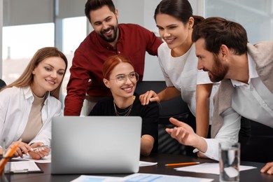 Photo of Team of employees working together in office