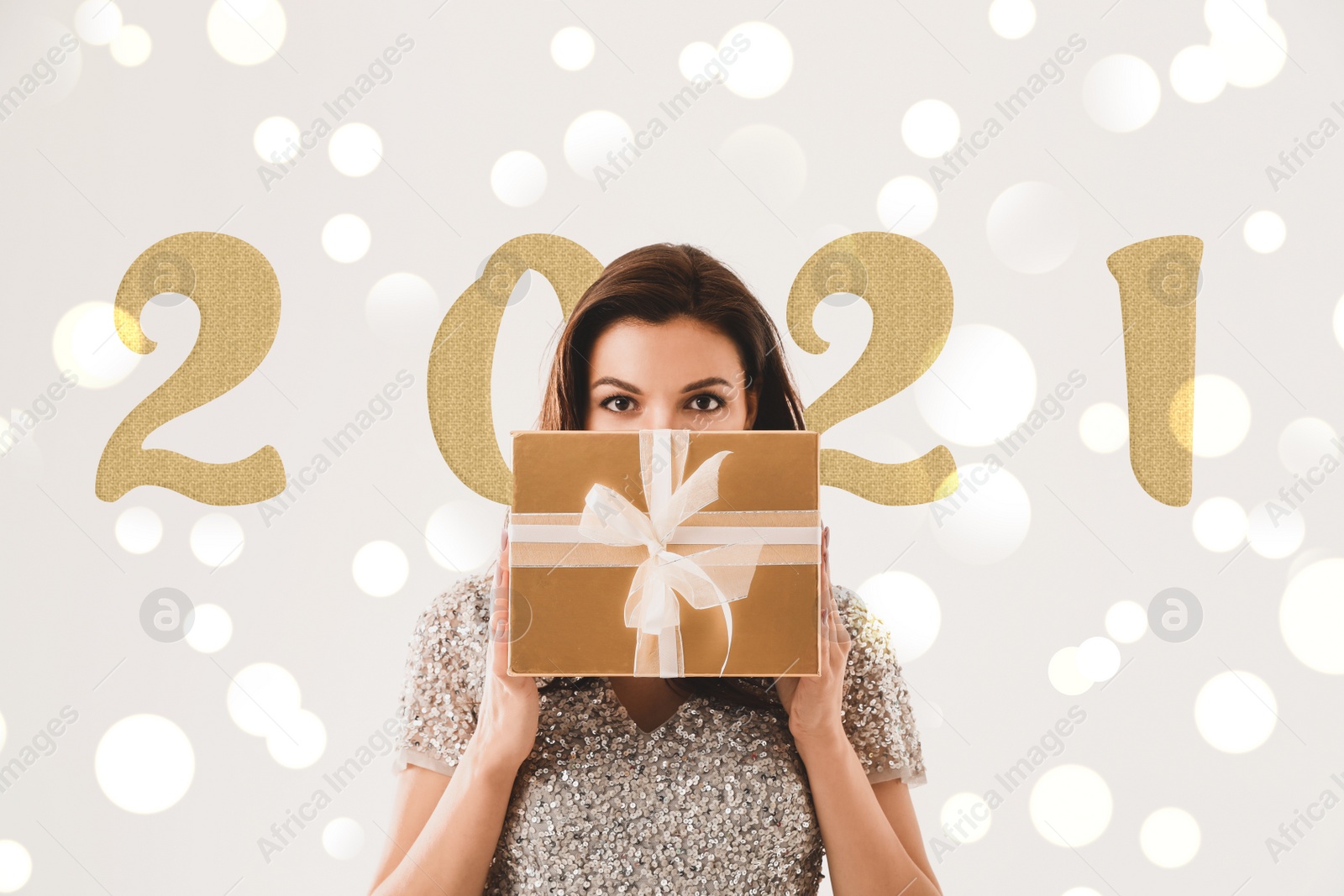 Image of Beautiful woman with Christmas gift against blurred background