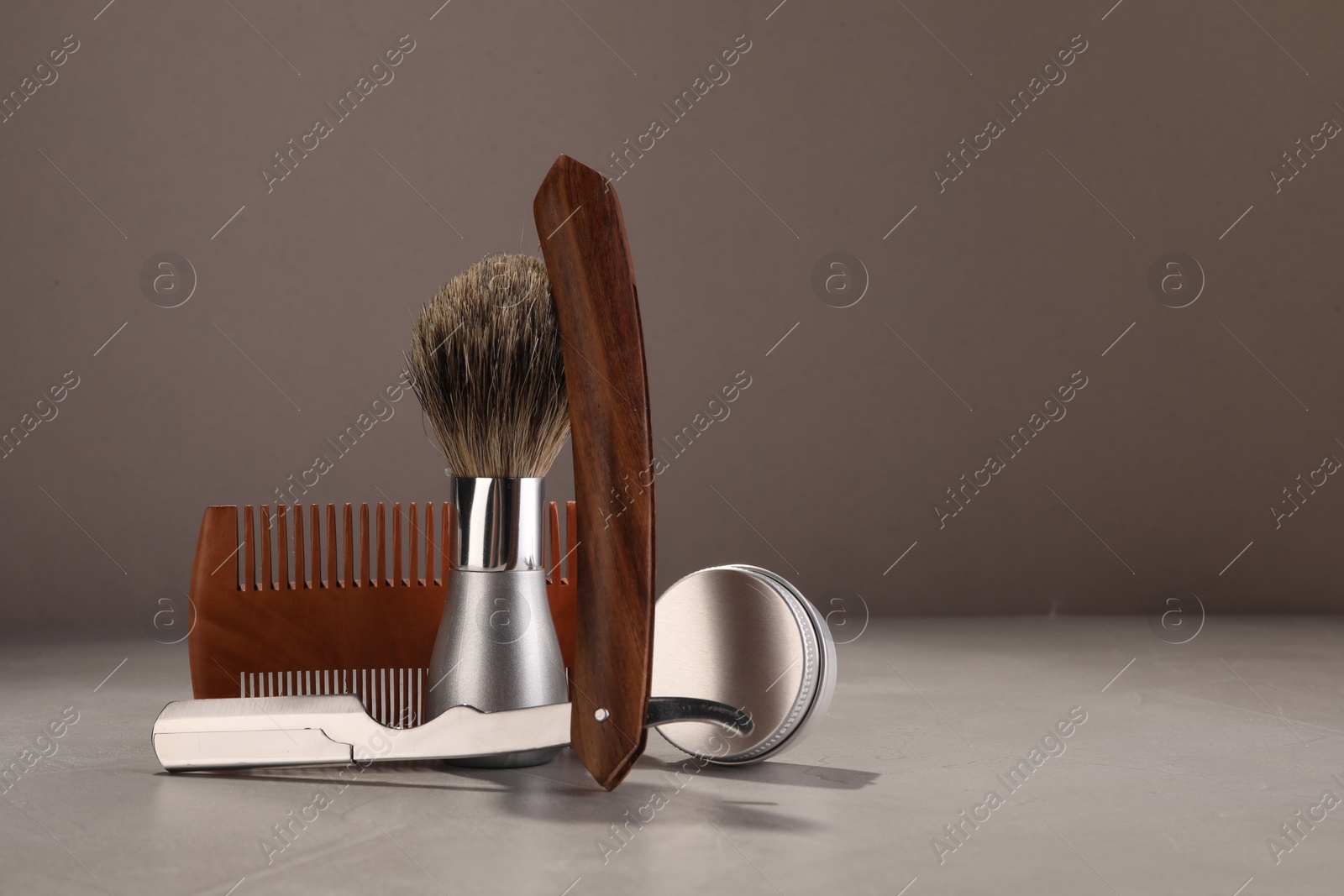 Photo of Moustache and beard styling tools on grey table. Space for text