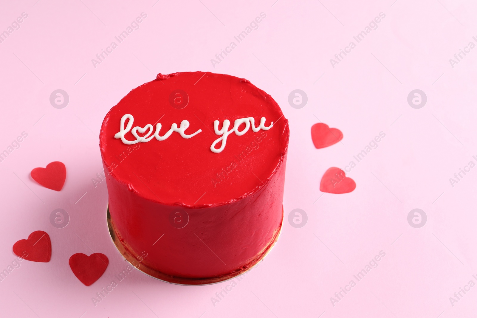 Photo of Bento cake with text Love You and paper hearts on pink table, space for text. St. Valentine's day surprise