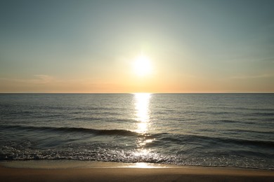 Picturesque view of sandy beach and sea at sunset