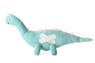 Photo of Toy dinosaur with sticking plasters isolated on white