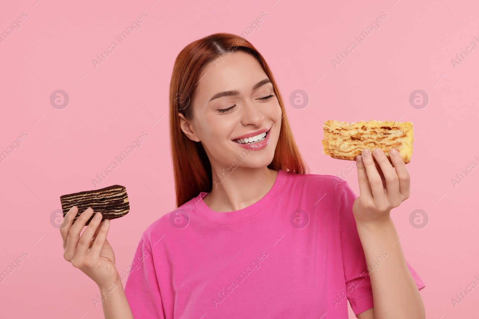 Photo of Young woman with pieces of tasty cake on pink background