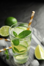 Photo of Delicious mojito and ingredients on marble board, closeup