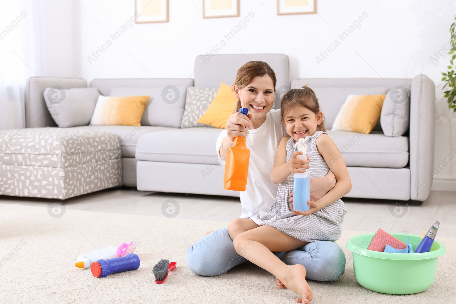 Photo of Housewife and daughter having fun after cleaning in room