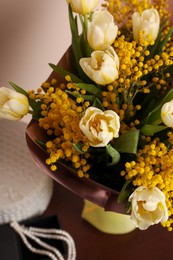 Photo of Bouquet with beautiful spring flowers and necklace on wooden table, above view