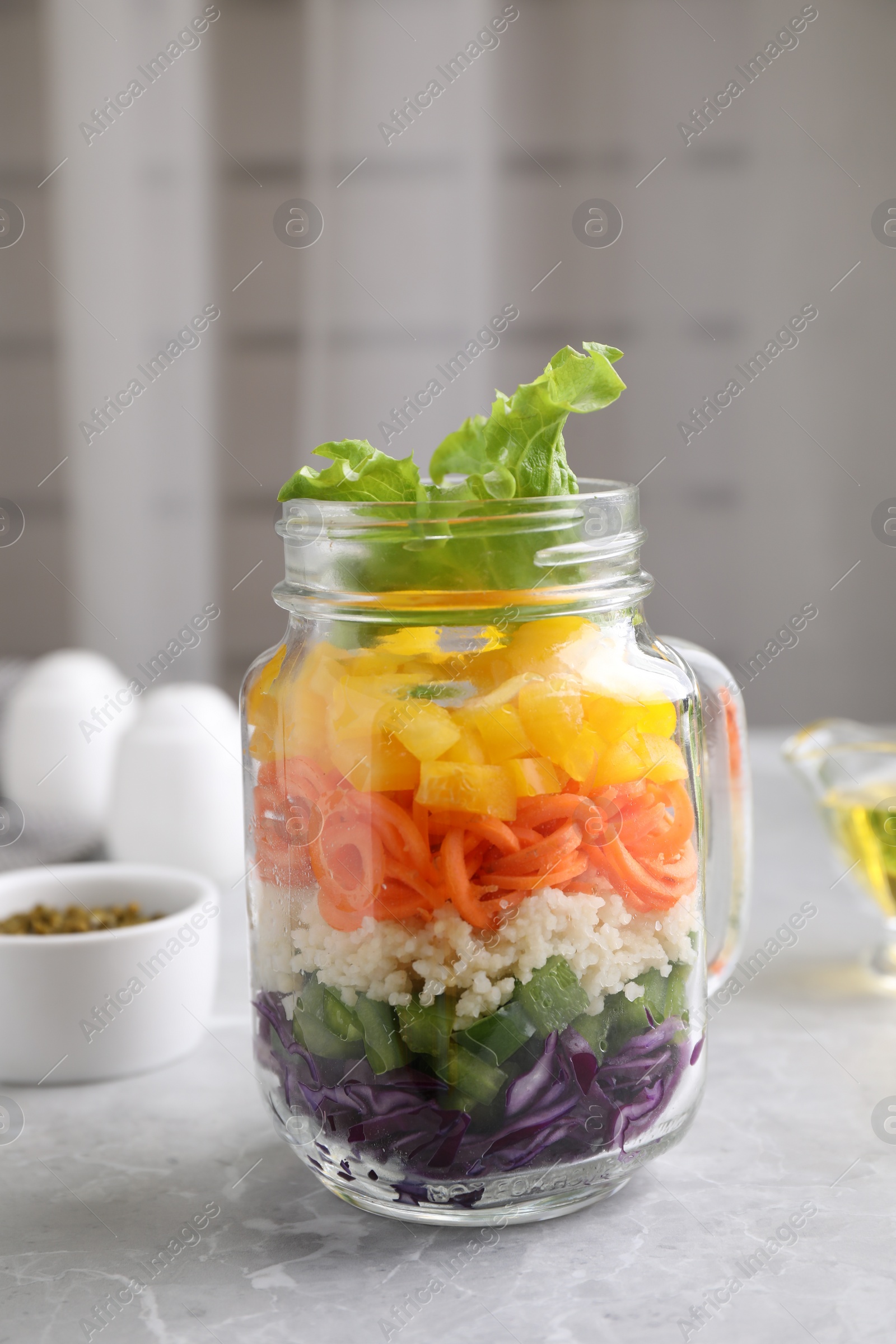 Photo of Healthy salad in glass jar on marble table