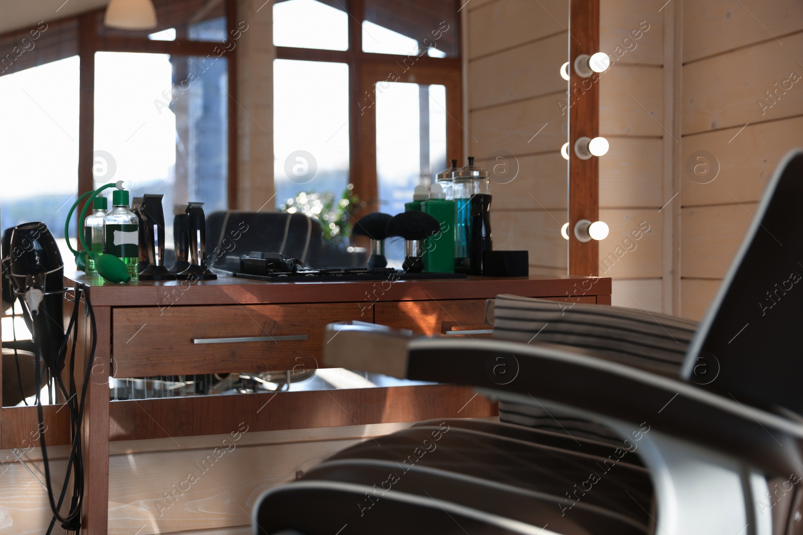 Photo of Stylish hairdresser's workplace with modern armchair and professional tools in barbershop