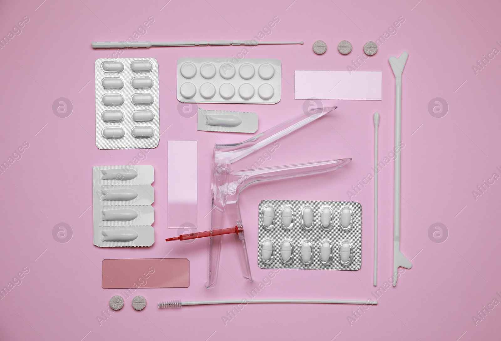 Photo of Sterile gynecological examination kit and medicaments on pink background, flat lay