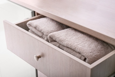 Photo of Clean towels in open drawer, closeup