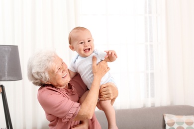 Photo of Happy grandmother with little baby at home