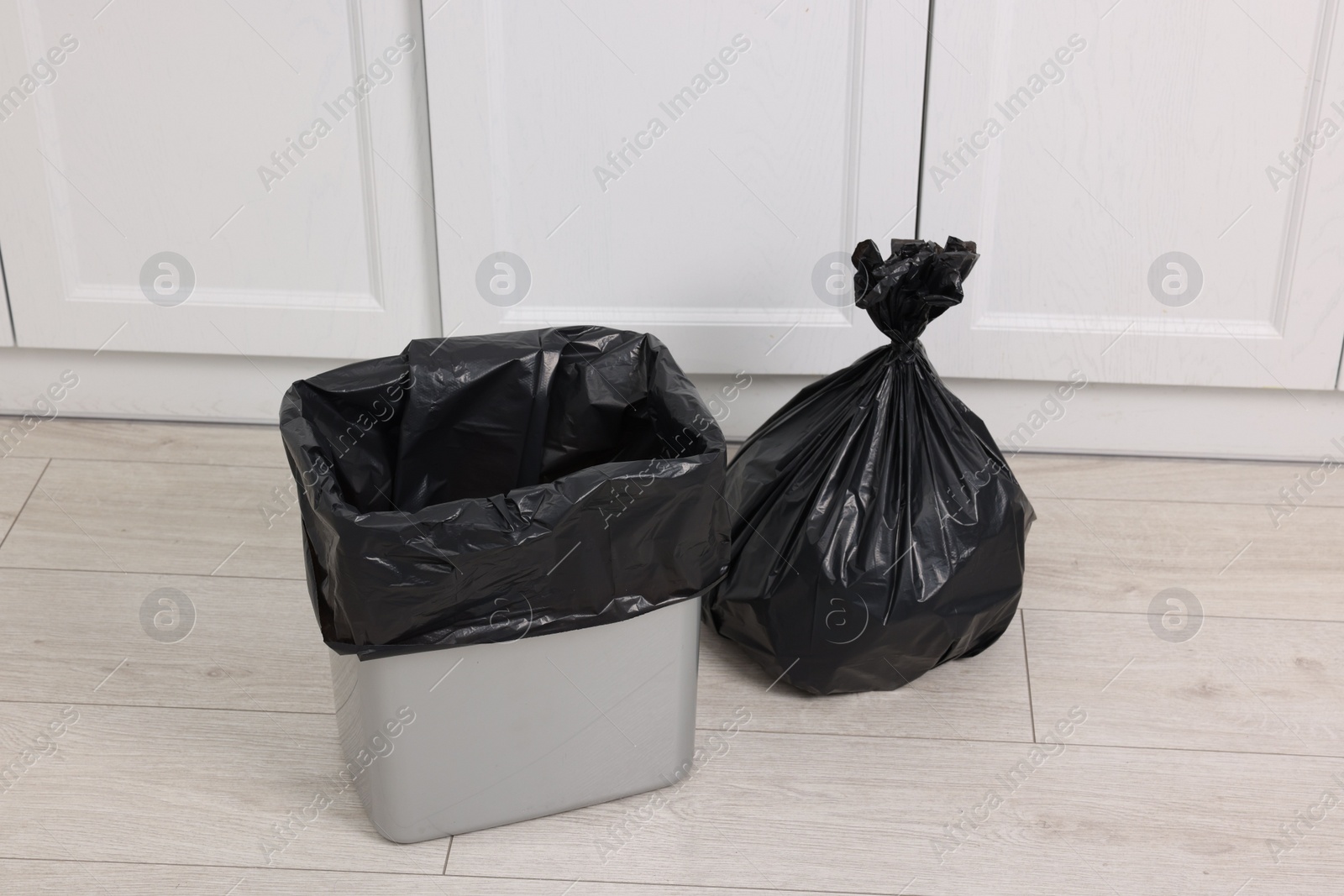 Photo of Plastic garbage bag and trash can indoors