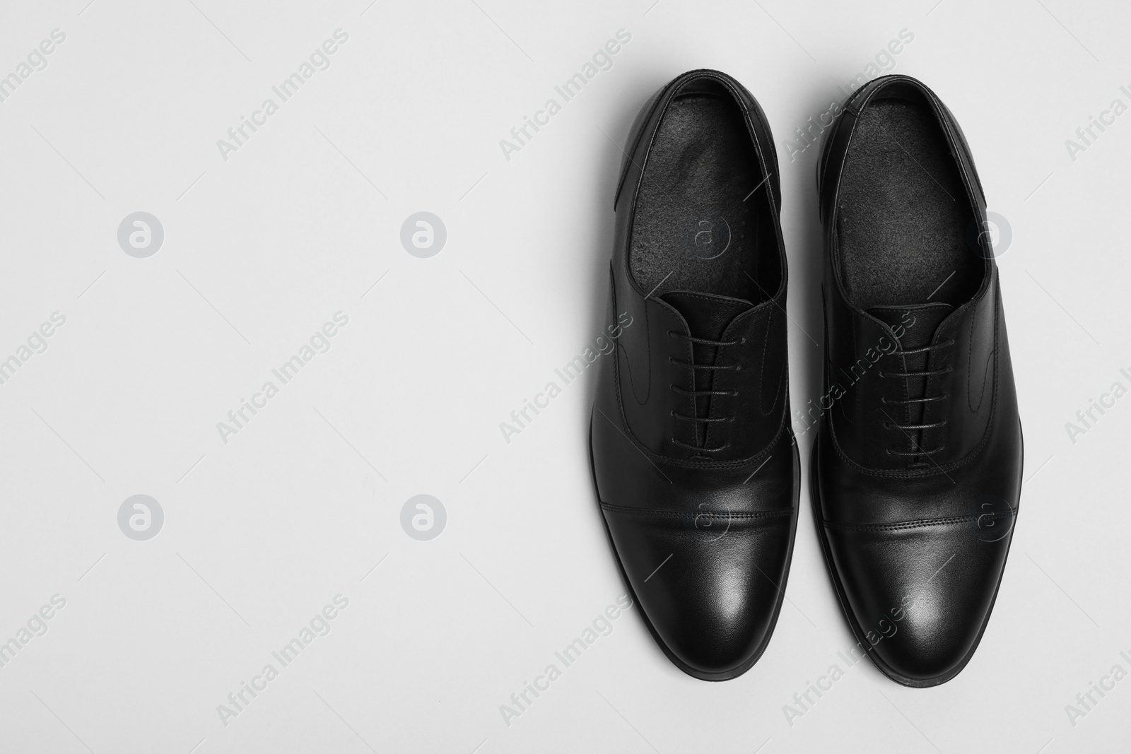 Photo of Pair of leather men shoes on white background, top view. Space for text