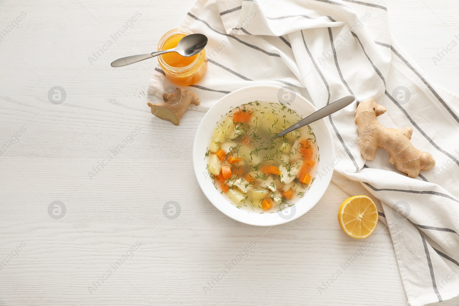 Photo of Flat lay composition with bowl of fresh homemade soup to cure flu on wooden background