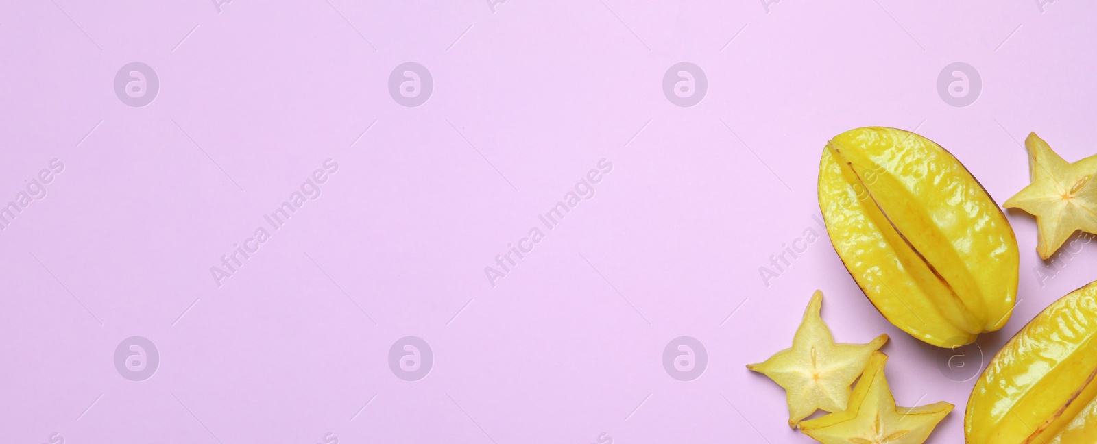 Photo of Delicious carambola fruits on violet background, flat lay. Space for text