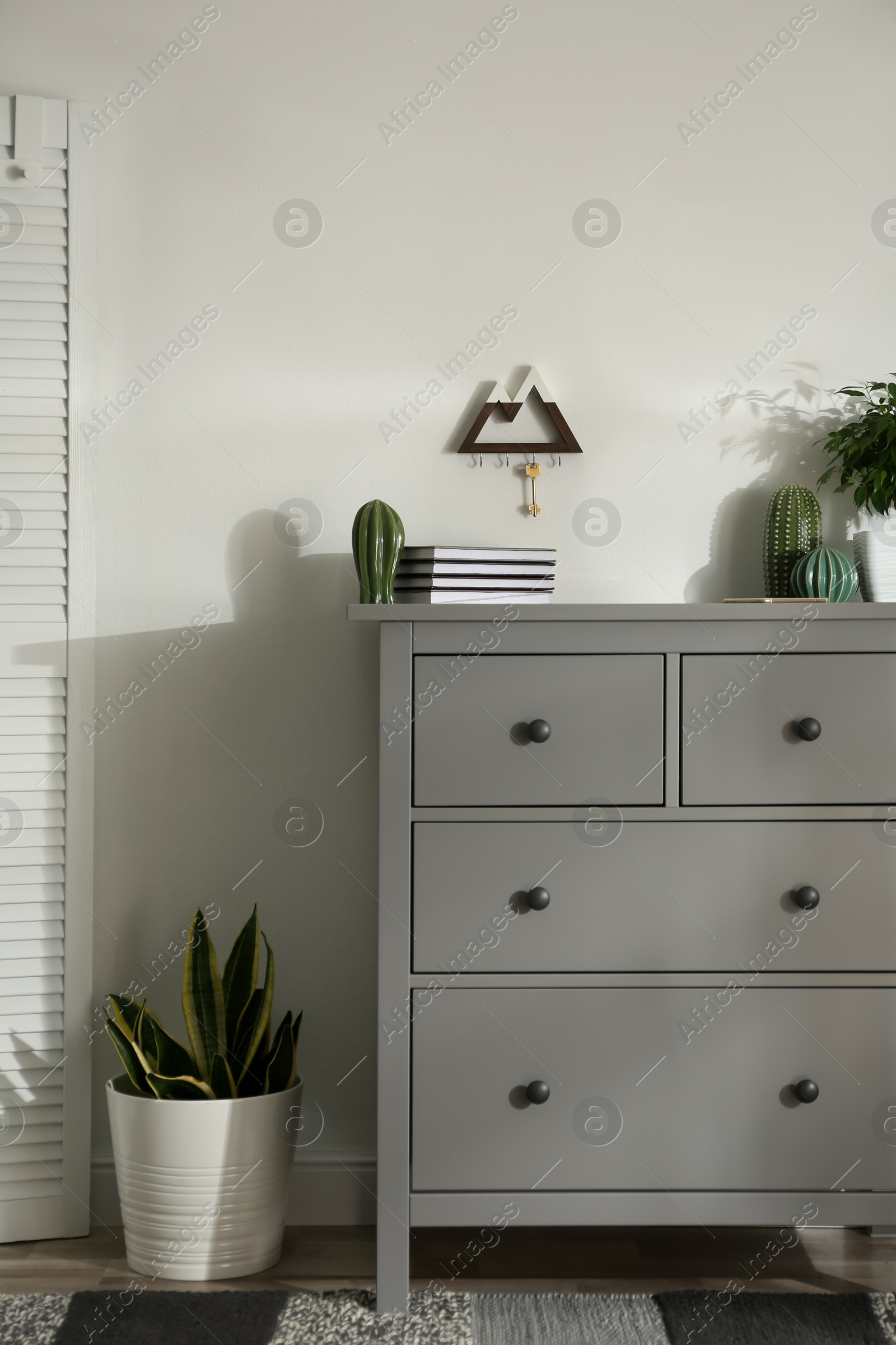 Photo of Grey chest of drawers in stylish room interior