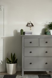 Photo of Grey chest of drawers in stylish room interior