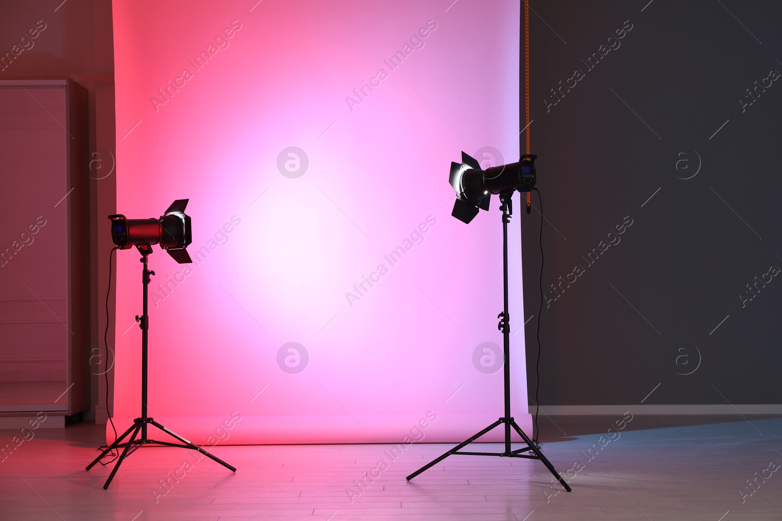 Photo of Photo background in neon lights and professional equipment inside modern studio