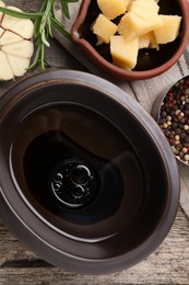 Bowl of balsamic vinegar with oil, parmesan cheese, and spices on wooden table, flat lay