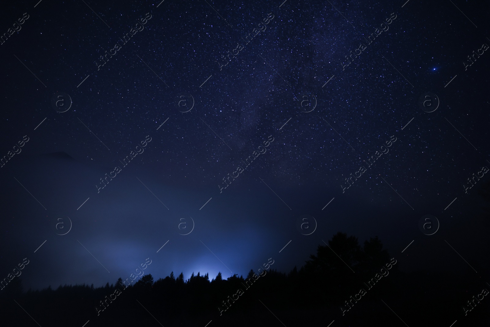 Photo of Beautiful view of starry sky over dark misty forest at night