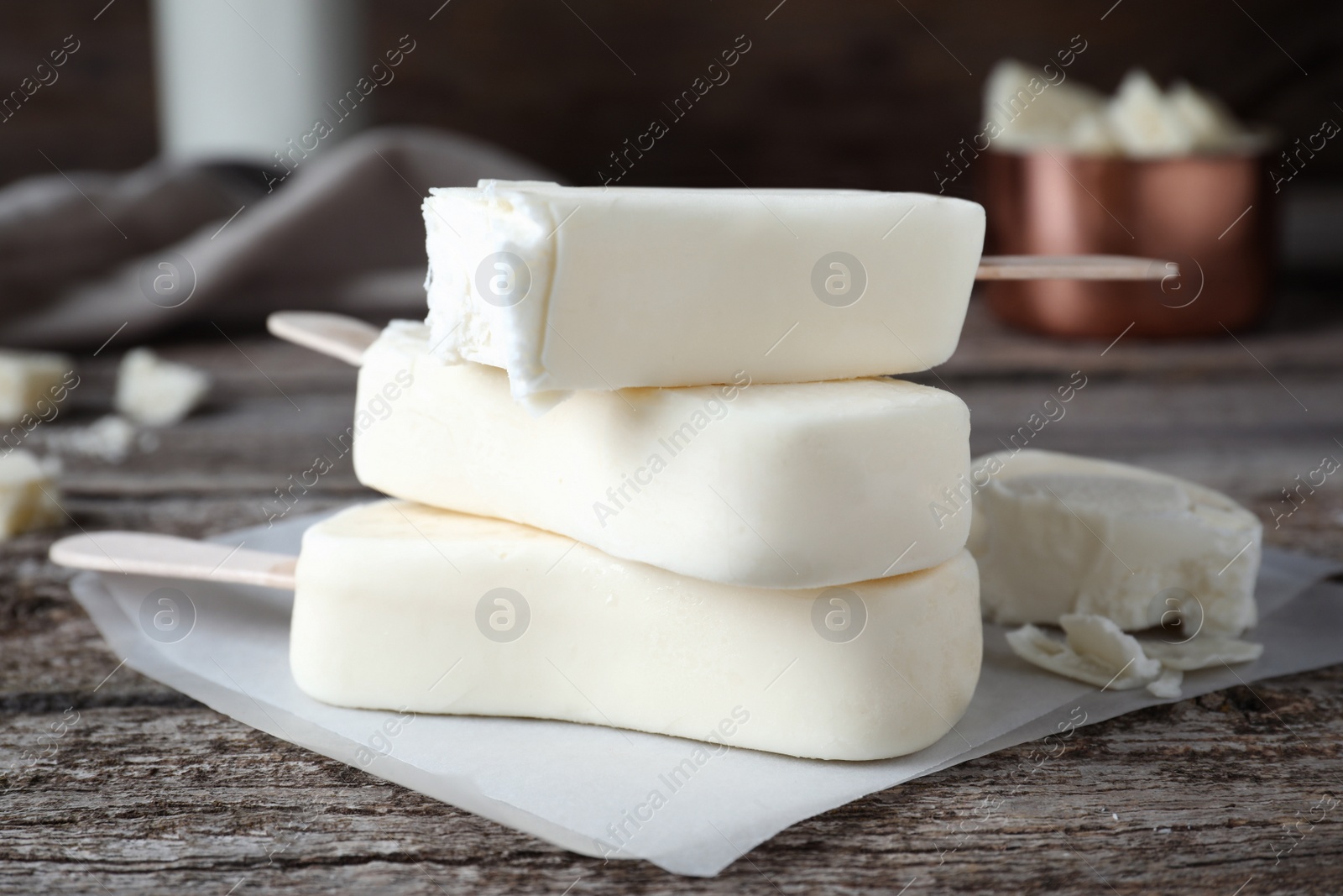 Photo of Delicious glazed ice cream bars on wooden table, closeup