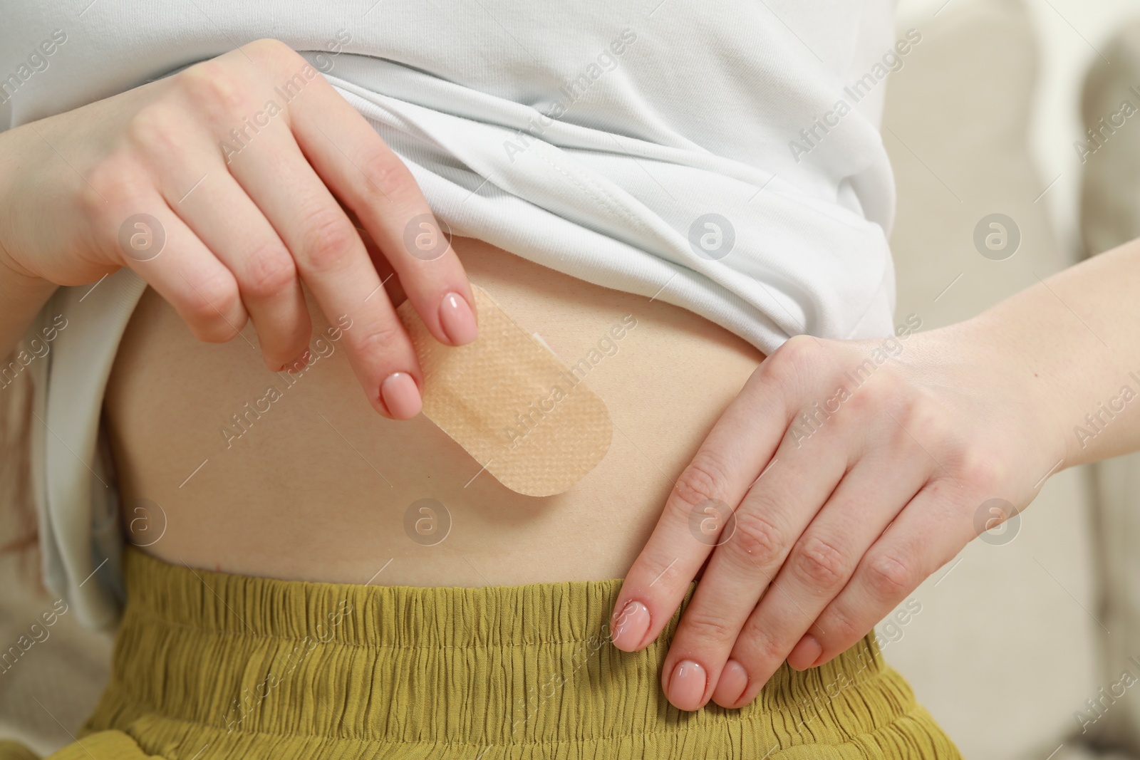 Photo of Woman applying contraceptive patch onto her body, closeup