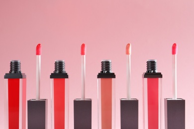 Photo of Liquid lipsticks with applicators on color background