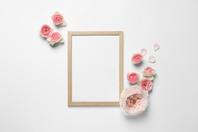 Photo of Empty photo frame and beautiful flowers on white background, flat lay. Space for design