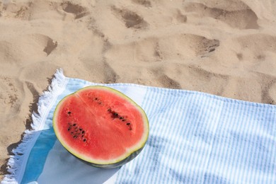 Photo of Half of fresh juicy watermelon on beach blanket near sea, space for text