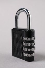 Photo of One steel combination padlock on grey background, closeup