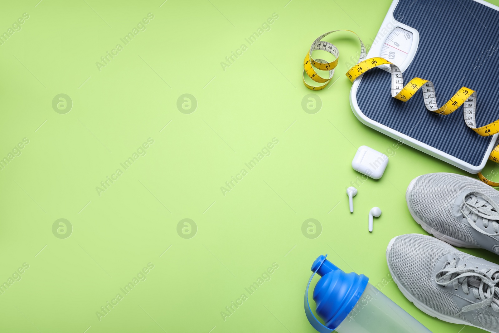 Photo of Flat lay composition with scales and measuring tape on green background, space for text