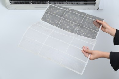 Image of Woman holding dirty and clean filters, closeup. Home air conditioner cleaning