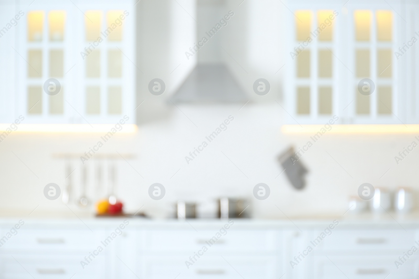 Photo of Blurred view of modern kitchen interior with white furniture