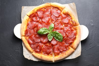 Tasty pepperoni pizza on black textured table, top view