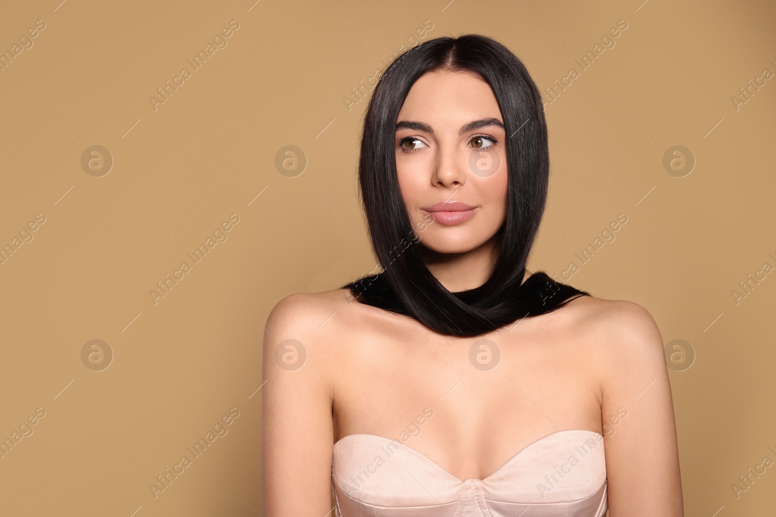 Photo of Portrait of beautiful young woman with healthy strong hair on beige background, space for text