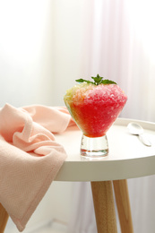 Shaving ice in glass dessert bowl on white table indoors