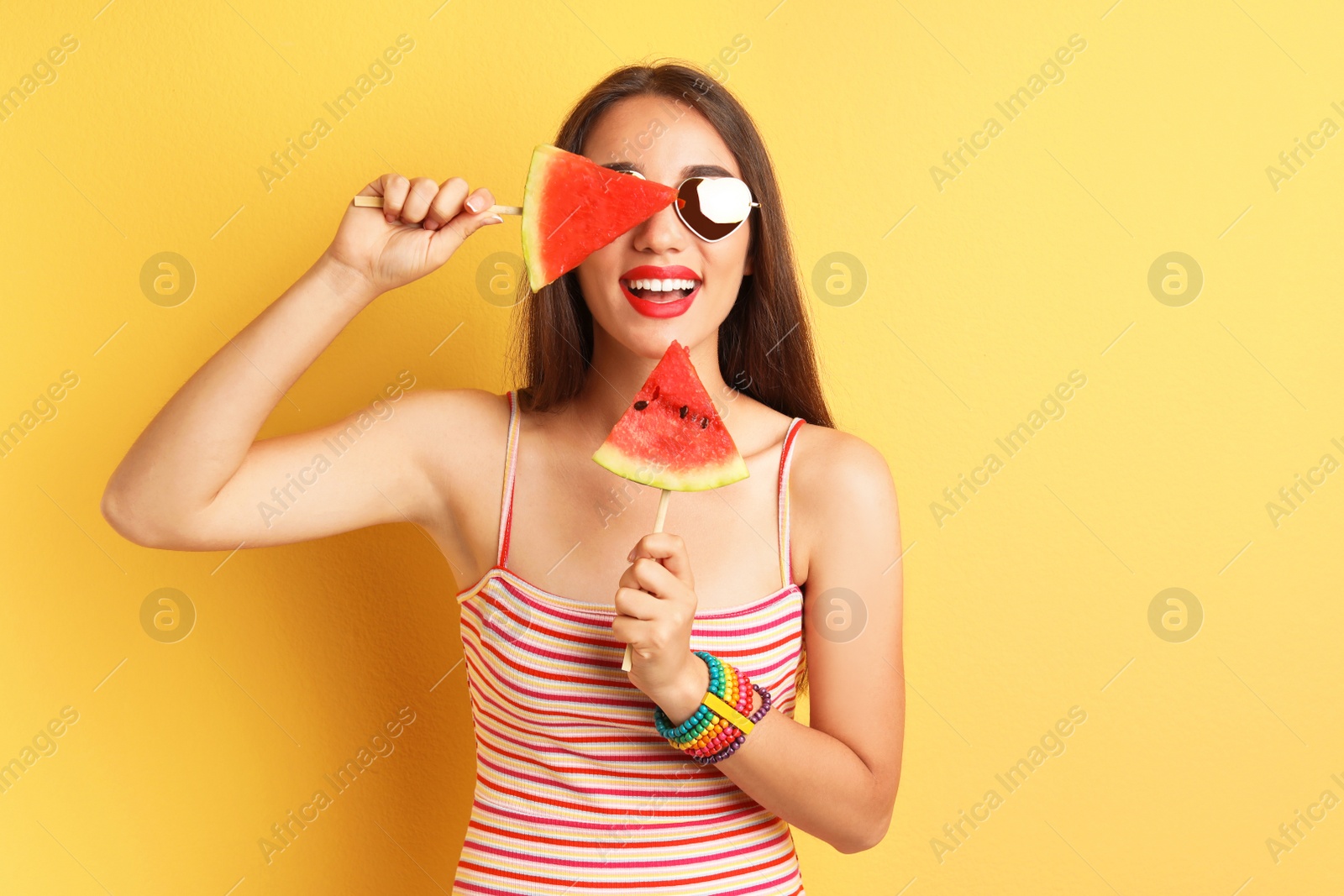 Photo of Beautiful young woman posing with watermelon on color background