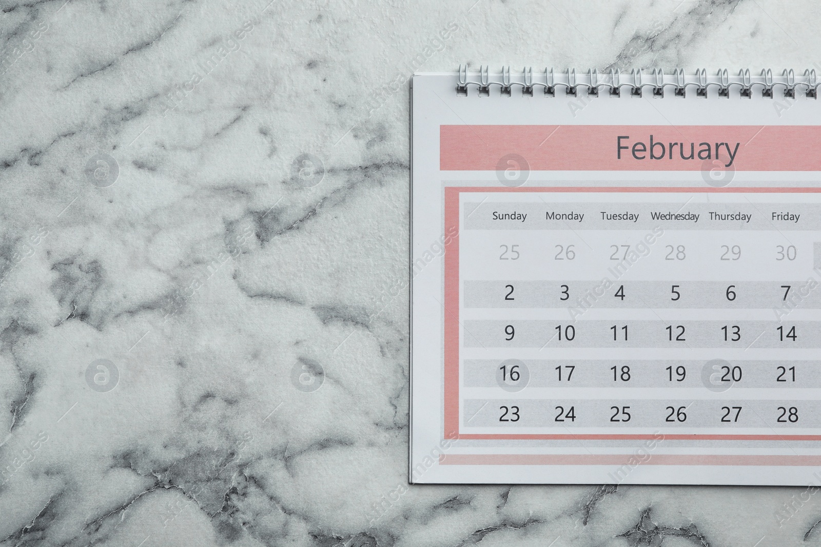 Photo of February calendar on marble background, top view. Space for text