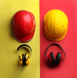 Photo of Flat lay composition with hard hats and headphones on color background. Safety equipment