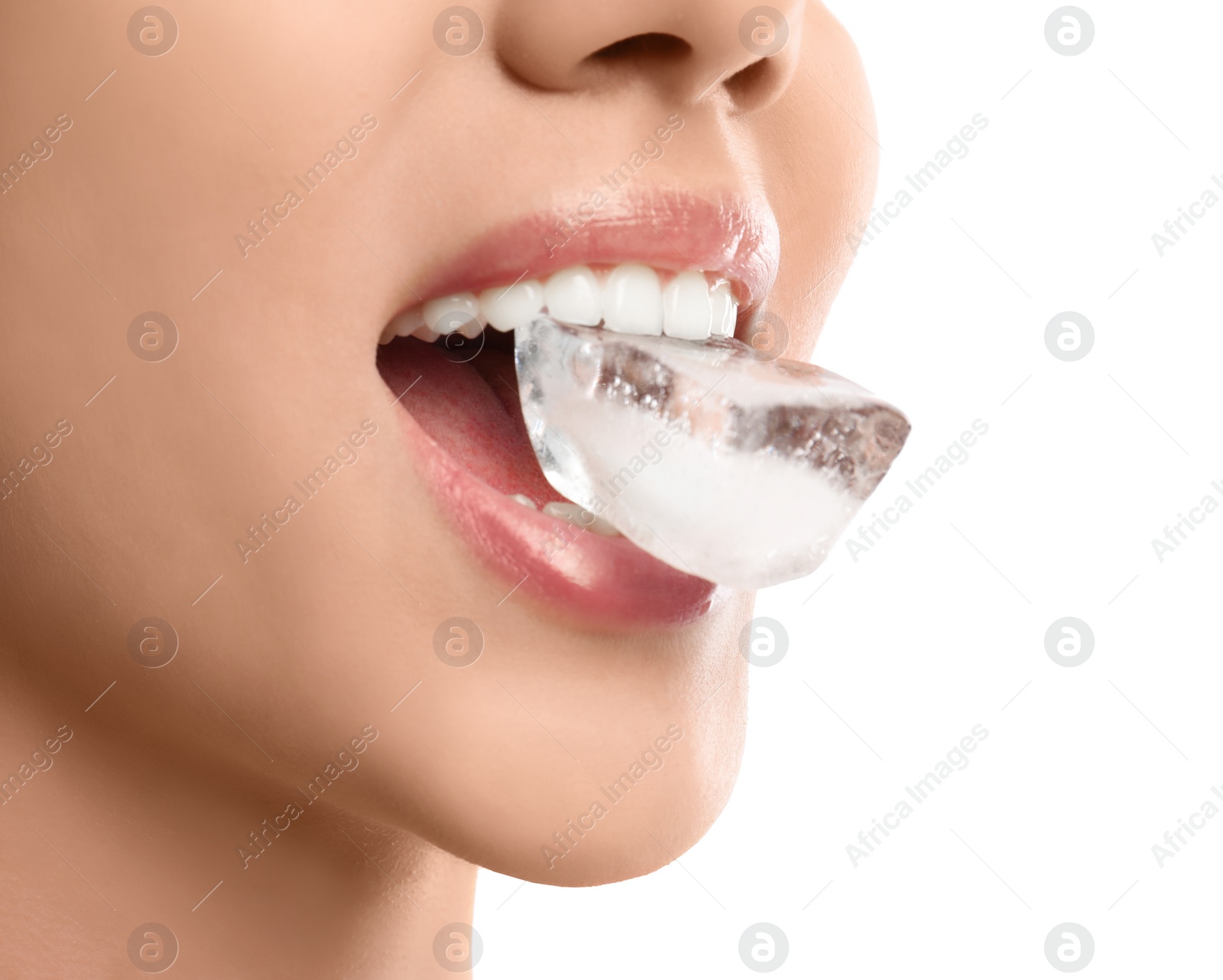 Photo of Young woman holding ice cube in mouth on white background, closeup