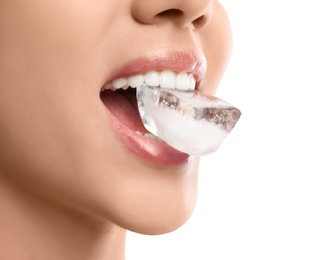 Photo of Young woman holding ice cube in mouth on white background, closeup